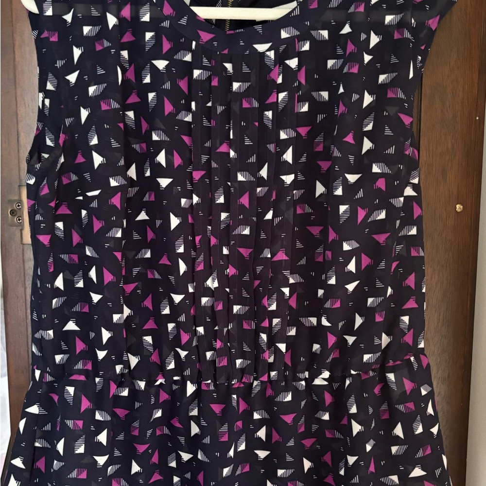 Stylish sleeveless woman’s shell with black zipper and peplum
